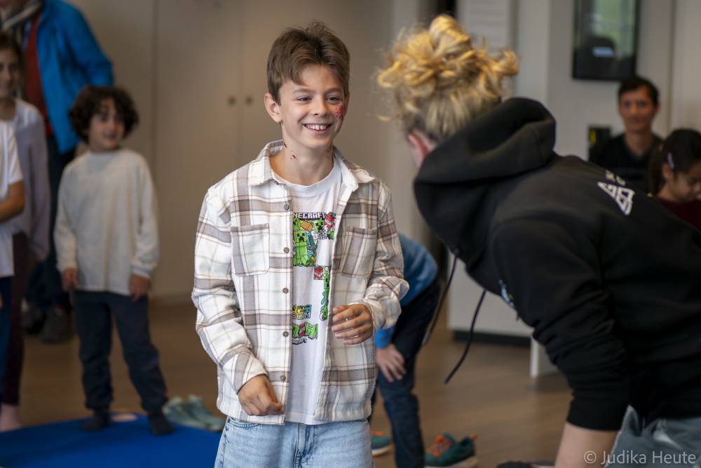 Junge mit einer (geschminkten) blutigen Backe beim Stunt-Workshop